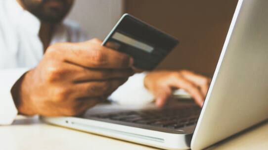 ノートパソコンにクレジットカード情報を入力しているユーザー